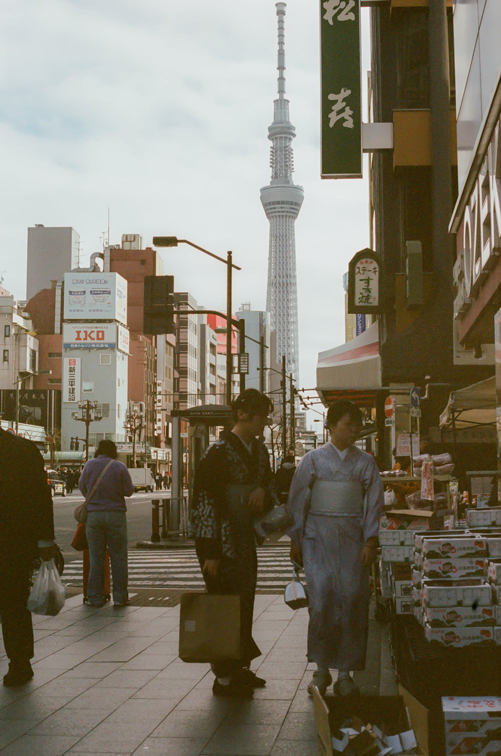 People walking on a street with the Tokyo Skytree in the background