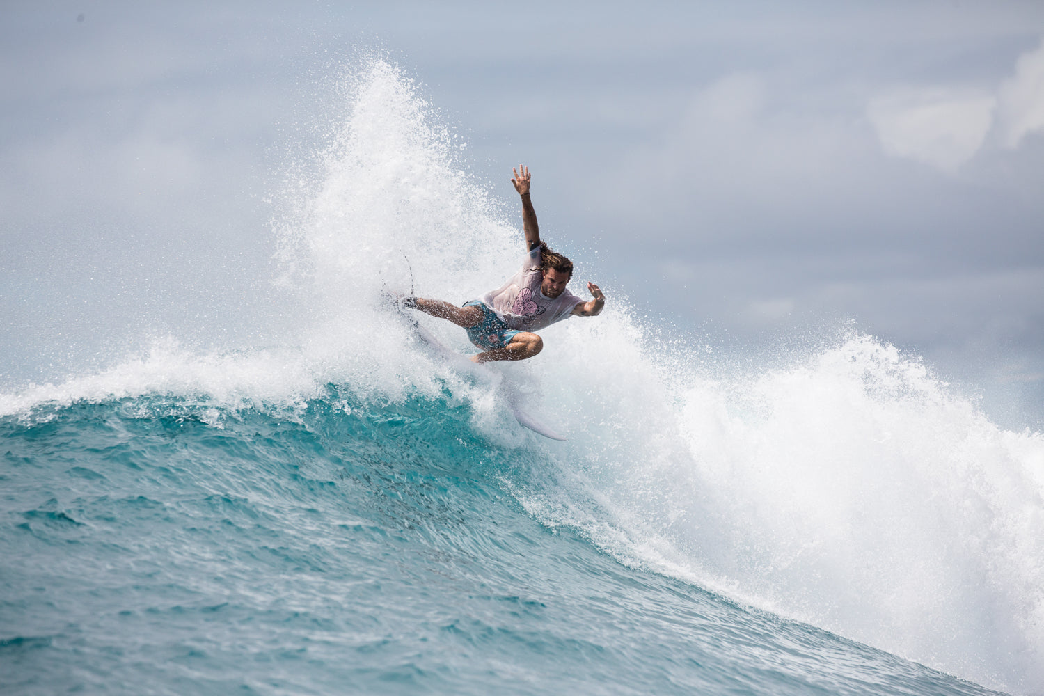 Surfer riding a wave with a clear sky in the background