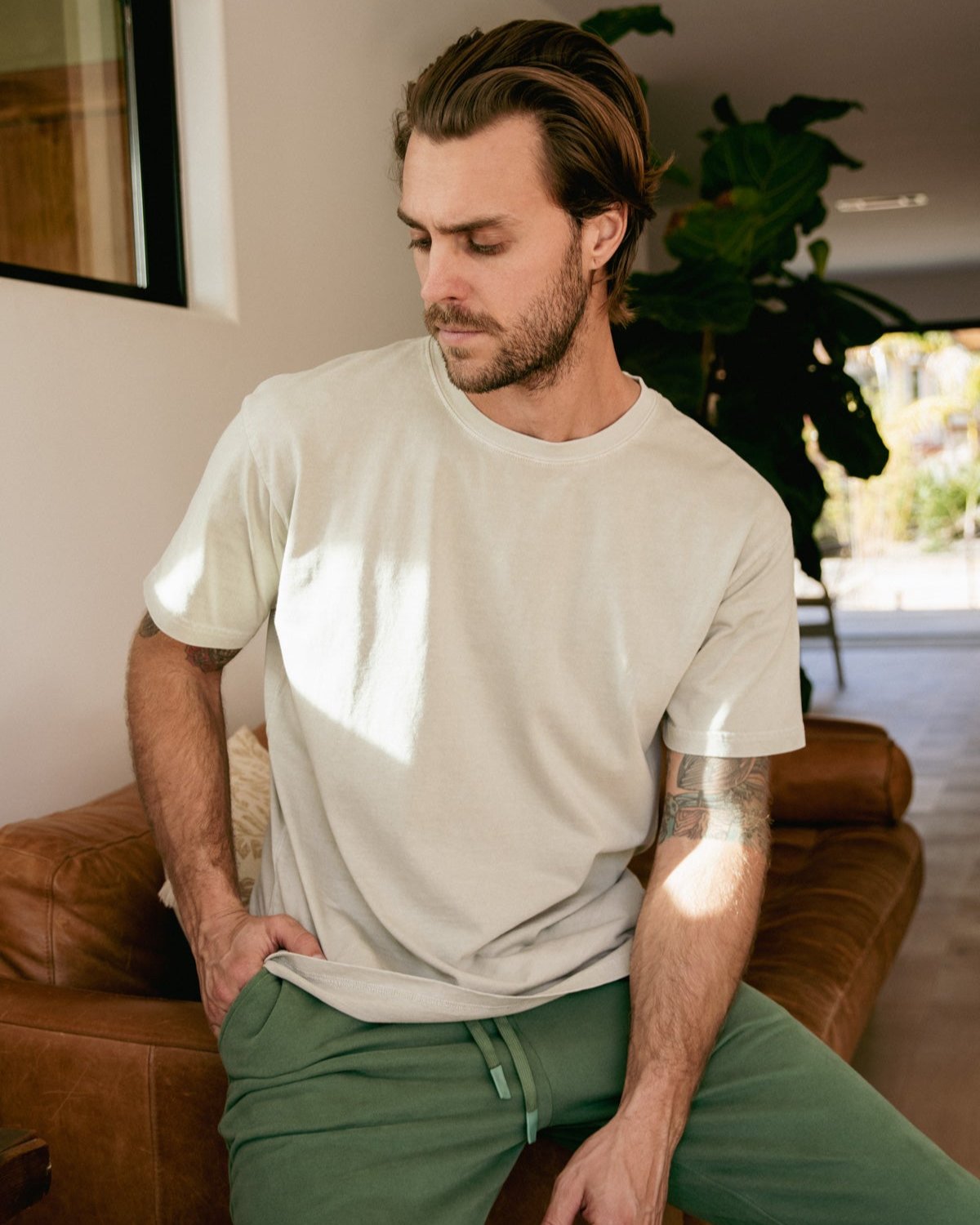 Light grey cotton t-shirt for men, featuring a relaxed fit and casual style, paired with green joggers.