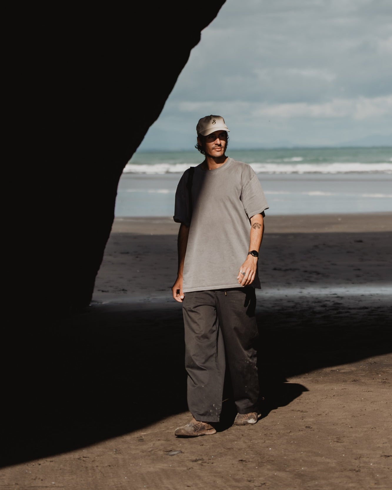 Man standing on a beach with ocean waves in the background