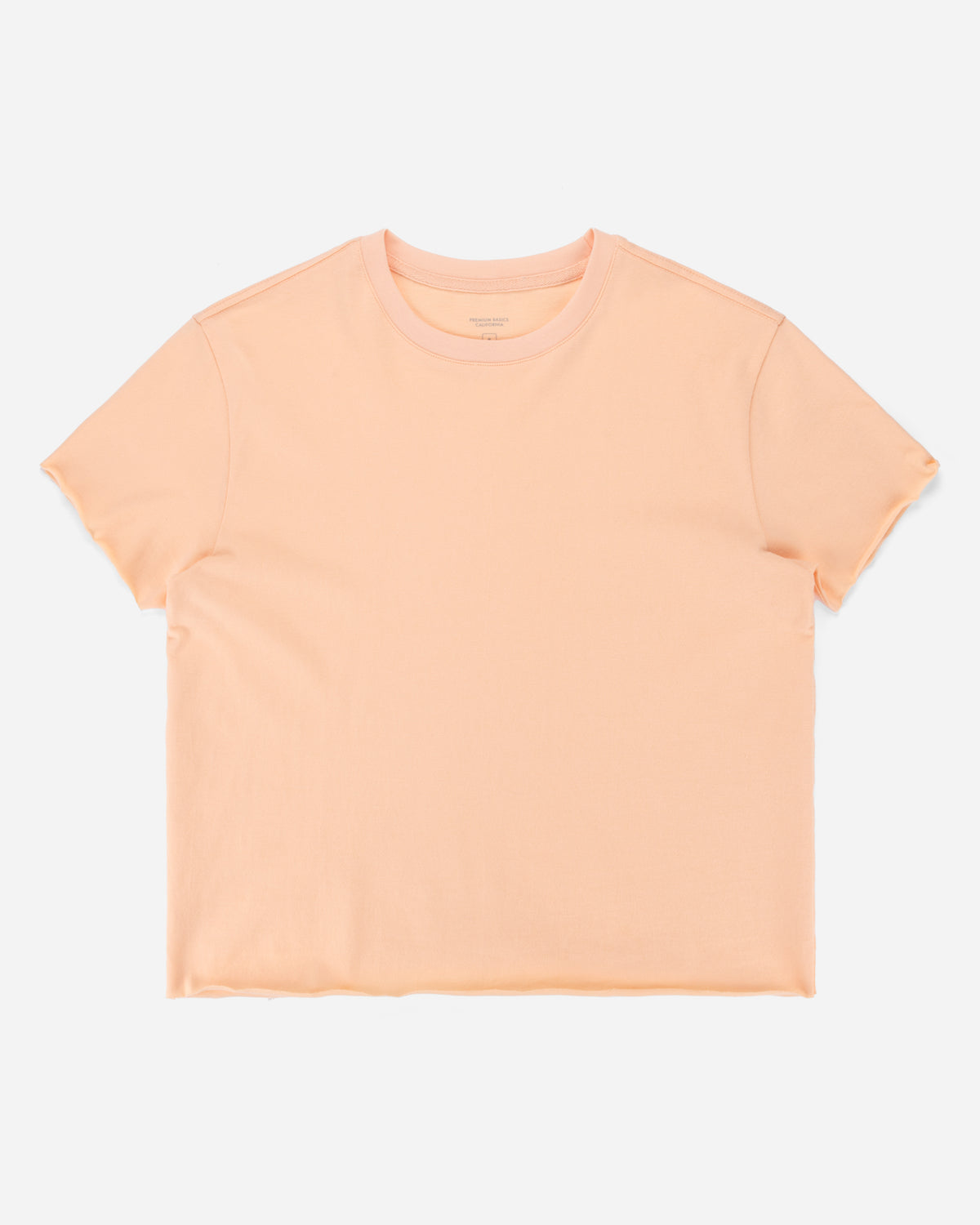 A light peach short-sleeve crewneck t-shirt laid flat against a light gray background.