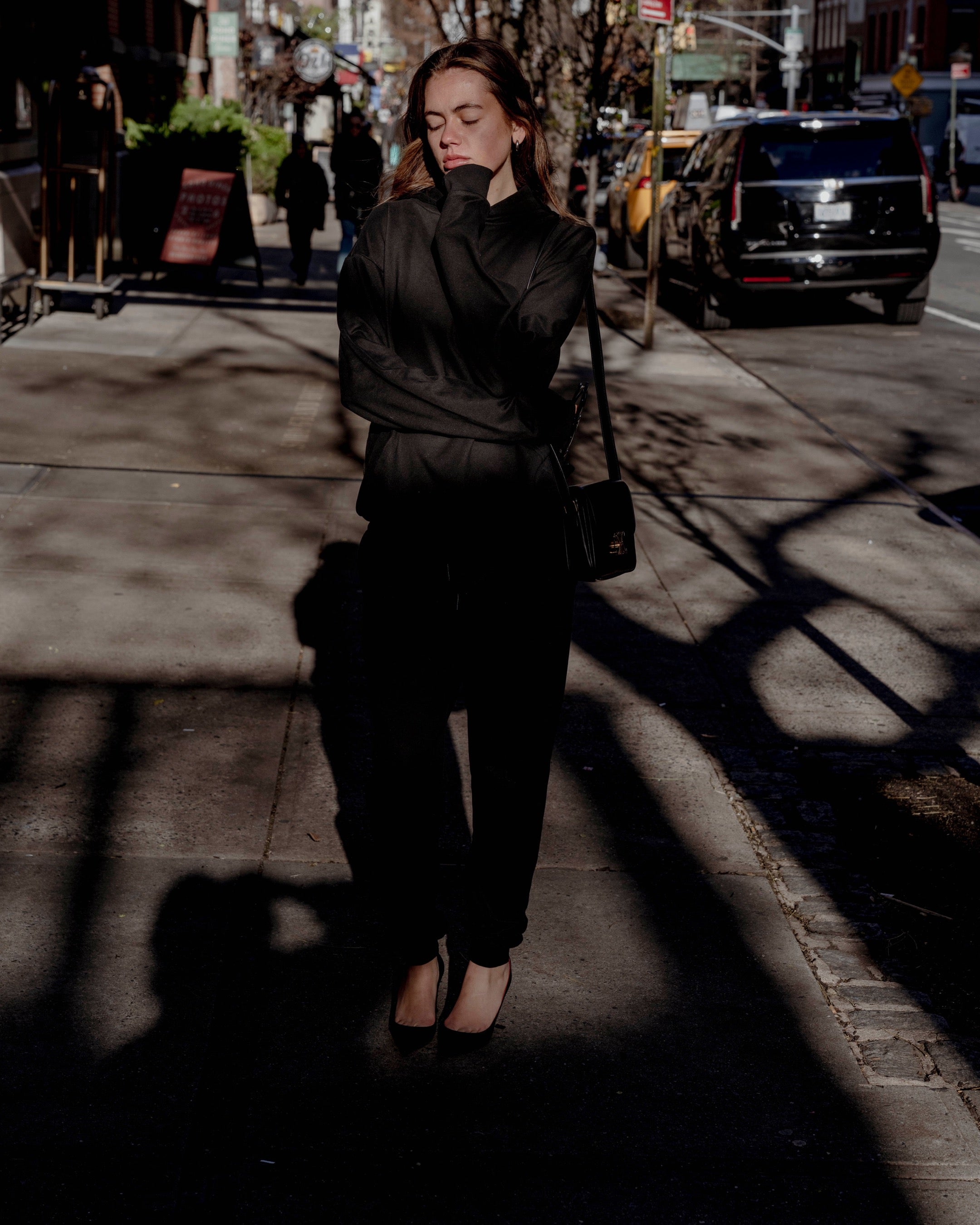 Woman in a black sweatsuit on the streets of NYC