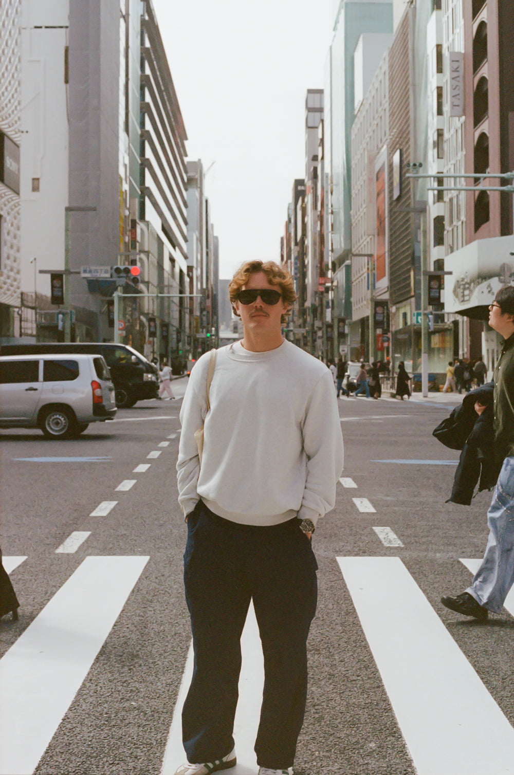Person standing on a city street with tall buildings in the background