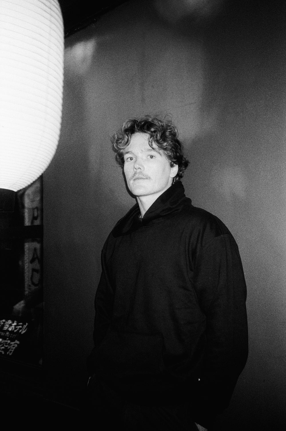 Black and white portrait of a person wearing a dark jacket against a plain background