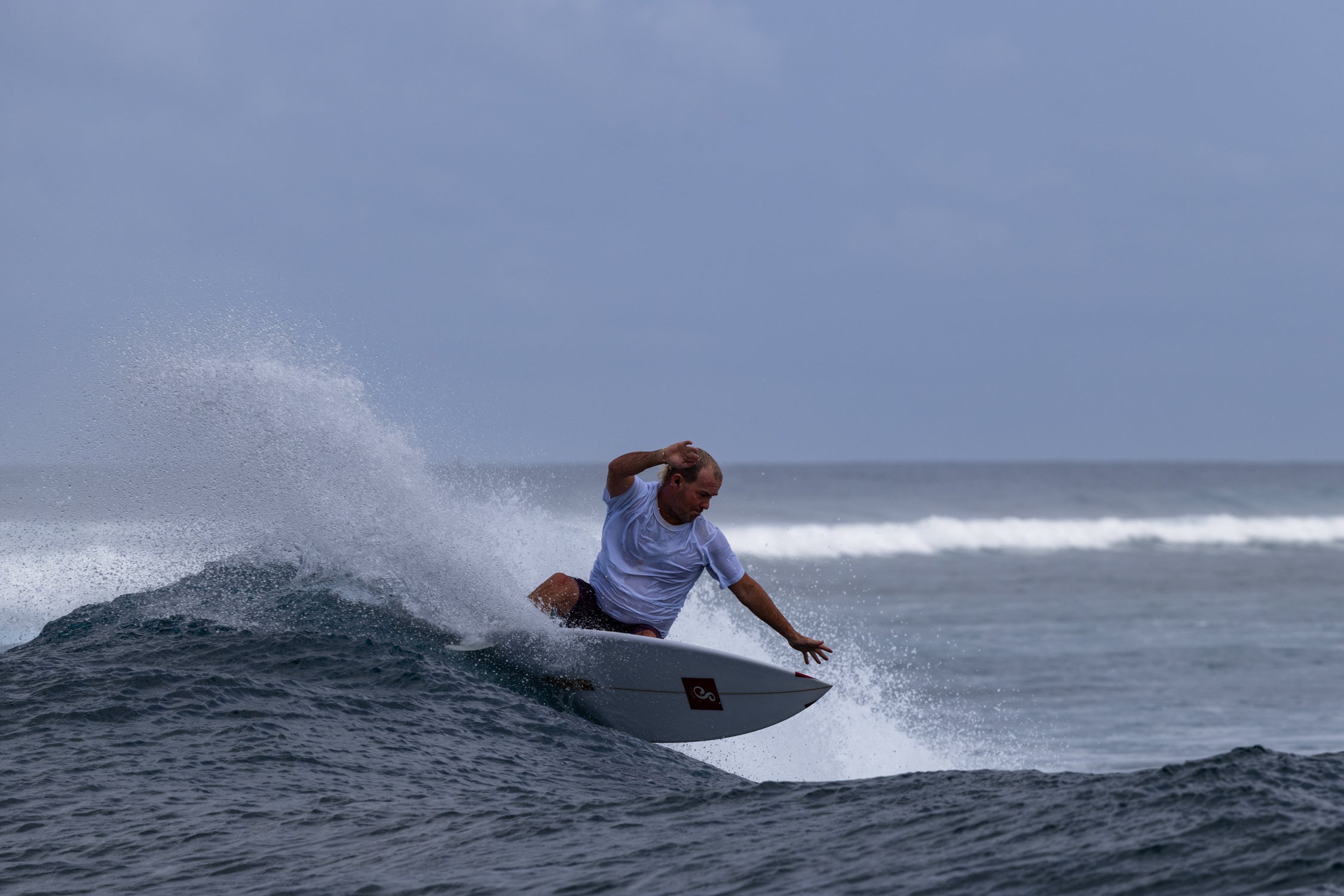Person surfing on a wave with a clear sky background