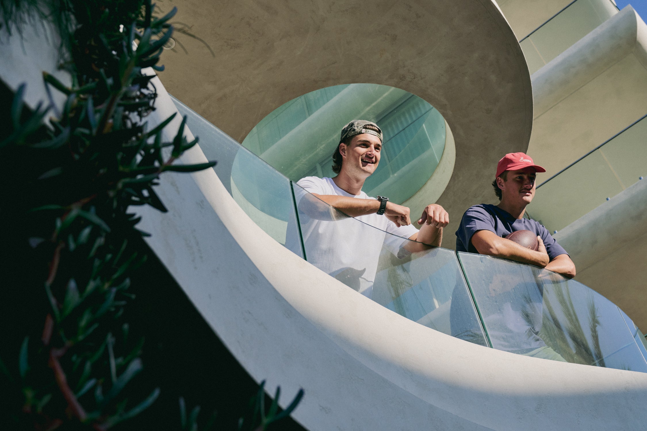 Two people standing on a modern architectural structure with a reflective surface.