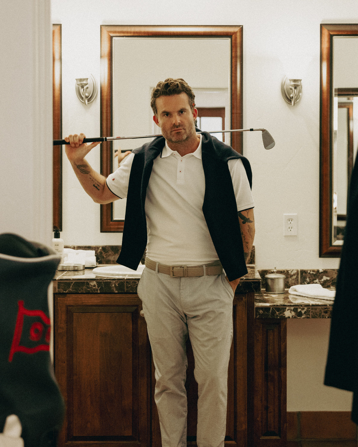 Man holding a golf club in a bathroom setting